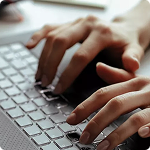 Fotografía de una mano sobre el teclado de un computador Fotografía de una mano sobre el teclado de un computador